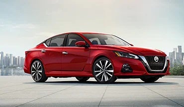 2023 Nissan Altima in red with city in background illustrating last year's 2022 model in King Windward Nissan in Kaneohe HI